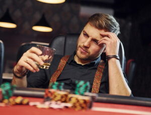 man playing poker drinking
