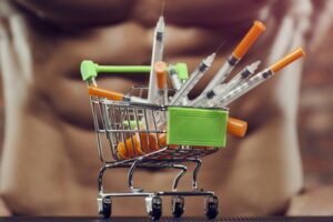 steroid syringes in shopping cart in front of man with six pack