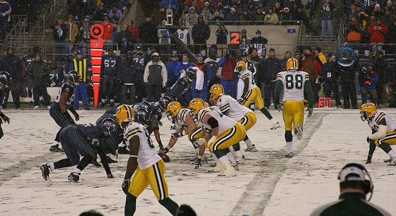 packers and seahawks play american football game in heavy snow