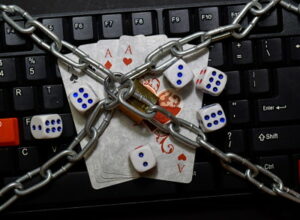 gambling ban cards and dice chained on keyboard