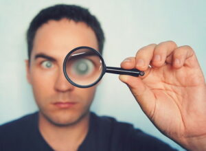 man looking through magnifying glass