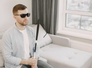 visually impaired man with stick and dark glasses