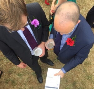 race card couple of guys reading one at a horse meeting